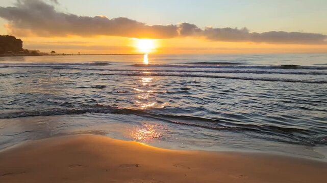 La Mer Noire, Varna, Bulgarie. Les rayons du soleil levant courent le long de la cr&ecirc;te des vagues glissant vers le rivage.