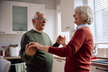 Fototapeta premium Happy senior man dancing with his wife at home.