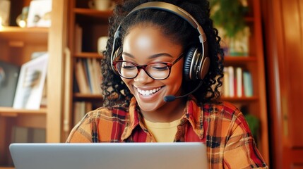 Smiling woman with laptop and headset in cozy home office environment