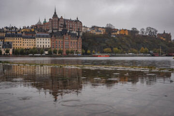 Naklejka premium Buildings by river during rainy day