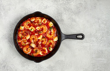 Greek saganaki, in an iron pan, saganaki with shrimp, shrimp in tomato sauce, with pepper and feta cheese, homemade, no people,