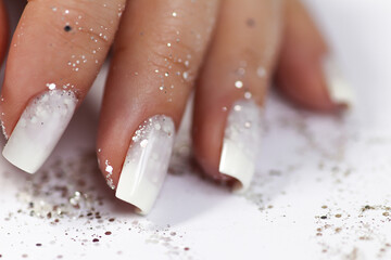 Milky white manicure with sequins on a narrowed nail shape.