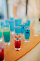Colorful shots are on the bar, party, Batman making drinks, alcoholism, addiction