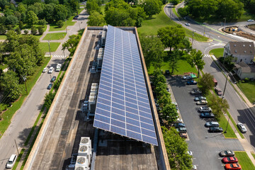 Apartment building with solar roof. Blue photovoltaic panels for producing clean ecological electric energy. Investing in renewable electricity concept