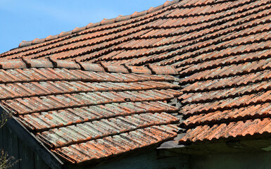 Naklejka premium On the roof of the house is an old red tile