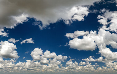 Bright landscape of blue sky with flying white clouds. Colorful summer skyscape