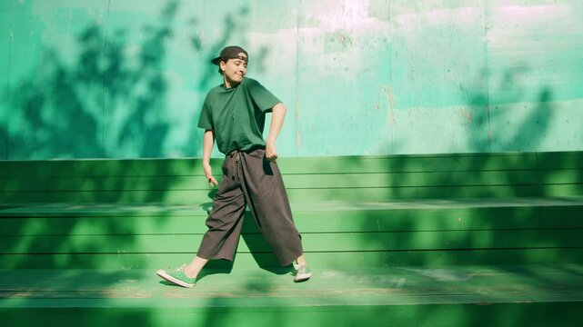 Young woman student dancing hip hop vogue. Modern dance choreography. Male professional dancer, breakdancer showing dance movings outdoor. Musical video.