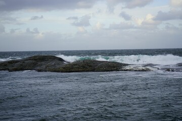 Scenic view of the open ocean with waves crashing against islets and reefs at Hustadvika, Norway