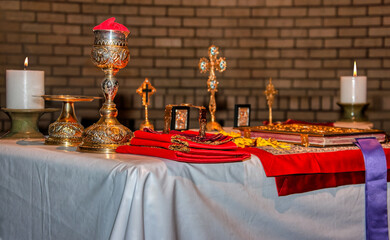 Christian Greek orthodox church, golden religious church tools. cross, chalice, bible, candles, and other various items used in orthodox ceremonial mass, byzantine rite