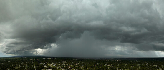 Rainstorm shower over Florida rural town in humid summer season. Rain water pouring down from stormy clouds