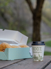 Coffee to go and rolls in a park. 100% recyclable packaging