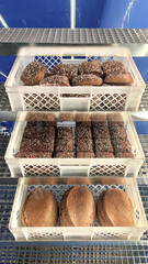 Storage and transport of freshly baked loaves of bread in a bakery for sale - industrial food production. Hand made rustic bead bakery food