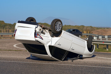 Accident on the road. A car upside down (with wheels up) after an impact.