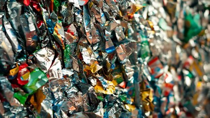 A close-up view of a tightly packed wall of recycled aluminum and plastic, ready to be processed for reuse, Visualize the process of recycling and its impact on reducing waste in landfills