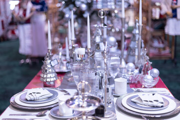 mock up shinning sliver Tableware on table in christmas night with candle and decoration with snow christmas tree and ornament