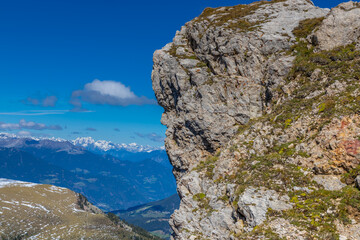 Sunny day in the Dolomites. Rocky mountain peaks of Dolomiti Alps in summer under the blue sky with some clouds prominent mountain summits landscape and stunning views of the alpine range and meadow