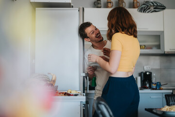 Fototapeta premium A couple shares a joyful and playful interaction in a modern kitchen environment, conveying love and happiness in domestic life. The scene reflects warmth and intimacy.