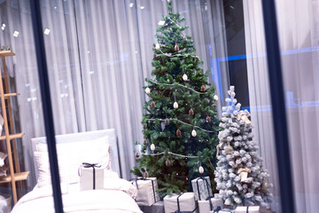 Christmas tree with gift box present and decoration ball and light bulb on festival time celebrations 