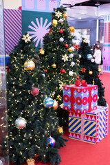Christmas tree with gift box present and decoration ball and light bulb on festival time celebrations 