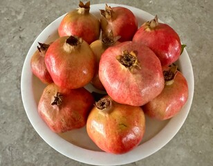 Fresh and organic pomegranates were displayed in a white bowl