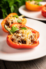 Stuffed peppers with herbs and cheese on the rustic background. Selective focus. Shallow depth of field.