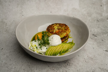 Vegetable pancakes with poached egg, avocado and sour cream