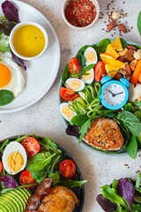 Vegetable plates with meat, fish and eggs. Complete diet for the day. Various breakfasts, lunches, snacks. Time to eat healthy foods. Eating by the hour. Health concept.