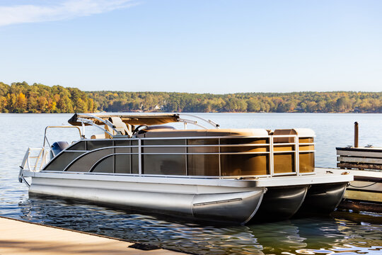 Pontoon boat at private marina dock on freshwater lake.