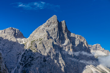 Sunny day in the Dolomites. Rocky mountain peaks of Dolomiti Alps in summer under the blue sky with...