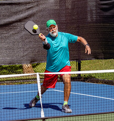 Pickleball player leans in to strike a sharp volley.