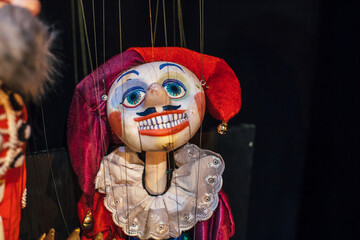 A colorful marionette puppet with a jester hat and vibrant facial features, showcasing artistry