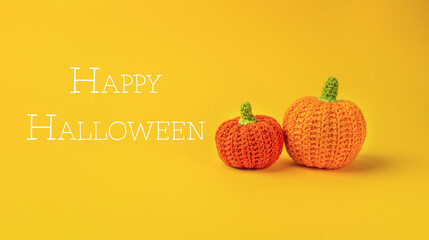 Two orange and yellow pumpkins are on a yellow background with Happy Halloween