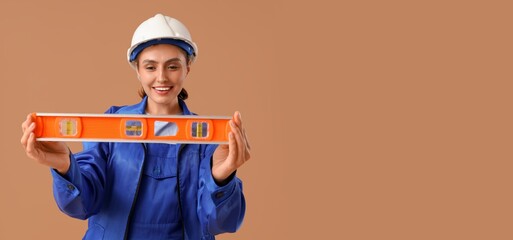 Female worker with construction level on brown background with space for text