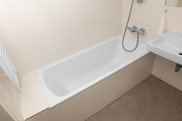 Interior of light bathroom with bathtub and sink