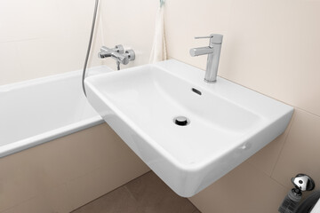 White sink with silver tap in light bathroom