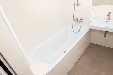 Interior of light bathroom with bathtub and sink