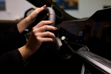 An up close image of a hand precisely adjusting a control in a luxurious automobile interior