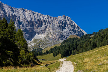 Sunny day in the Dolomites. Rocky mountain peaks of Dolomiti Alps in summer under the blue sky with...