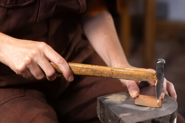 Obraz premium craftswoman - blacksmith hammering metal