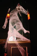 A spooky scene with cobweb covered tombstone, a skull and dim lighting