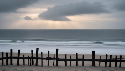 a fence is in front of the ocean at sunset