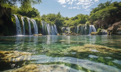 Obraz premium Crystal-clear water with a backdrop of waterfalls and scenic greenery