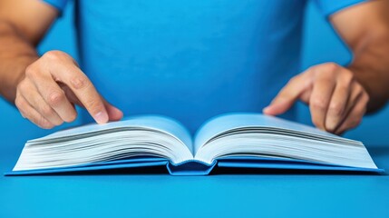 Close-up of Open Book with Man's Hands Reaching Towards It