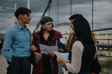 A group of business people engaged in a focused discussion on a city street. They appear to be analyzing documents, indicating a collaborative effort. The urban setting adds to the dynamic energy.