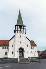 Obraz premium Ancient street and the white church of the city of Ronne, Bornholm Island, Denmark. High quality photo