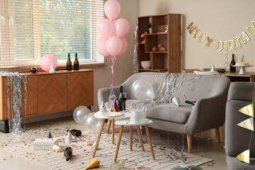Interior of messy living room after Birthday celebration with sofa, tables and party decor