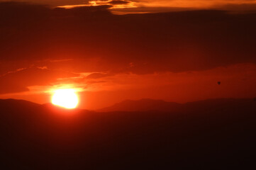 The sun rises behind the mountains