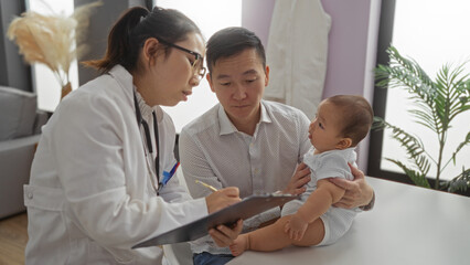 Fototapeta premium Doctor consulting father holding baby boy in a clinic, highlighting family care and support in a professional healthcare setting.
