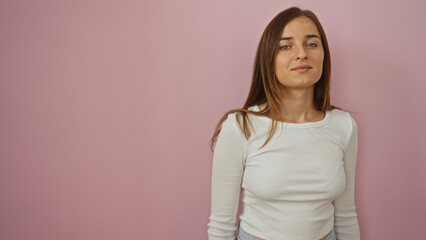 Attractive young caucasian woman with blonde hair and a beautiful smile posing over an isolated pink background wall