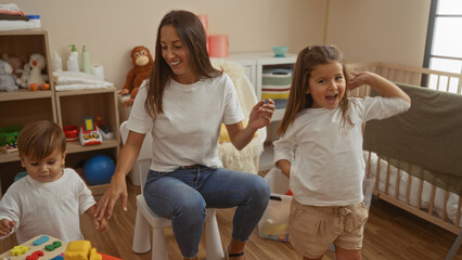 Woman with two children playing in a cozy bedroom setting, showcasing a family moment filled with love and happiness, in a beautifully decorated interior space.